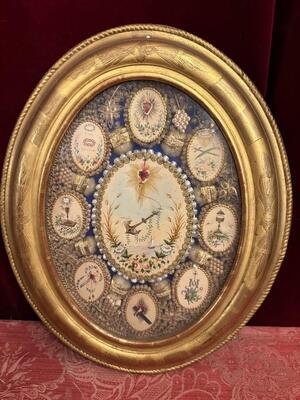 Multi Reliquary / Monastery - Work en Oval Wooden Frame / Glass / Multiple fully hand - made ornaments / Gold Leaf Papier - Rolle / Hand Painted depictions, France 19 th century ( Anno 1860 )